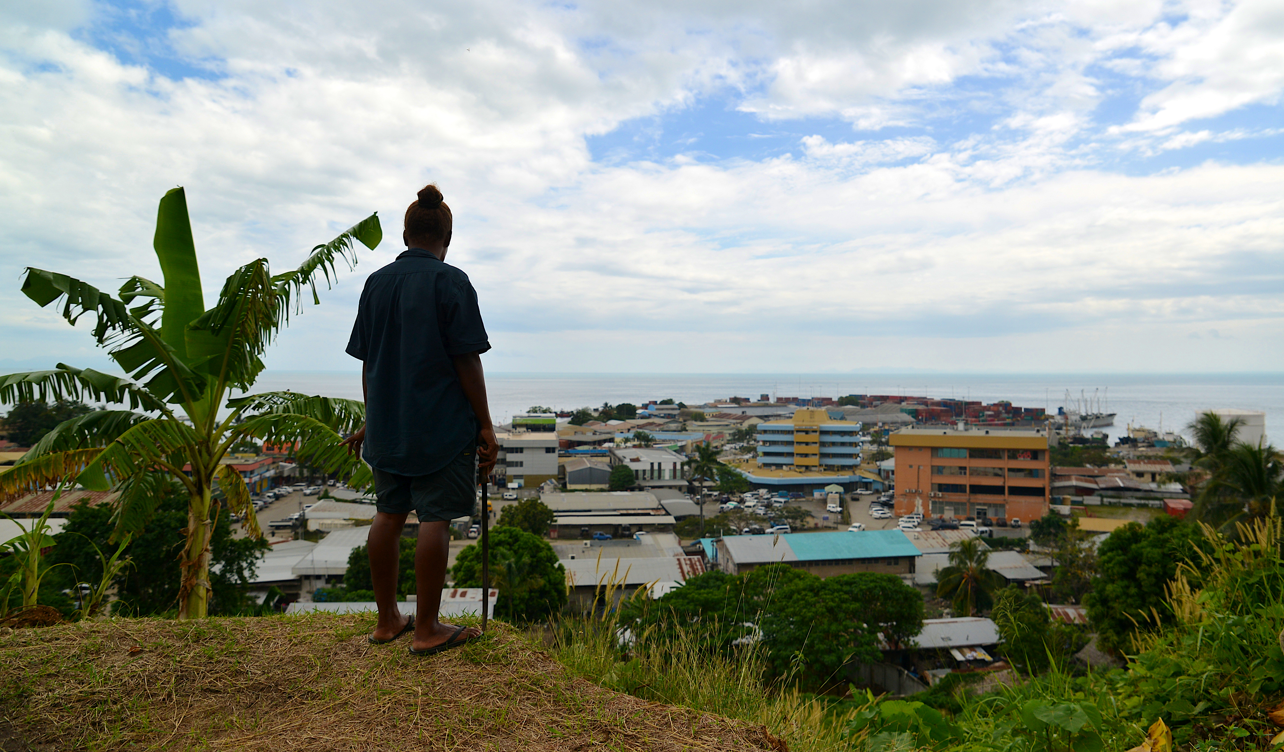 A gardener working on the grounds of Solomon Islands National Parliament takes in the view of the capital