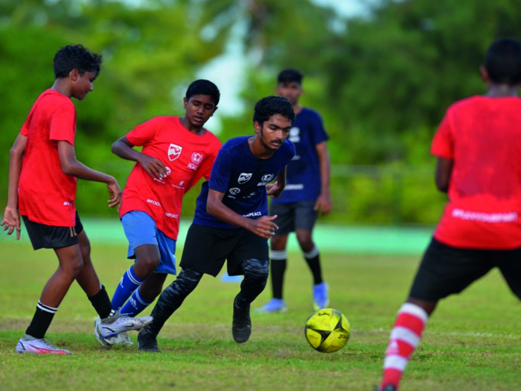Boys playing football in Maldives