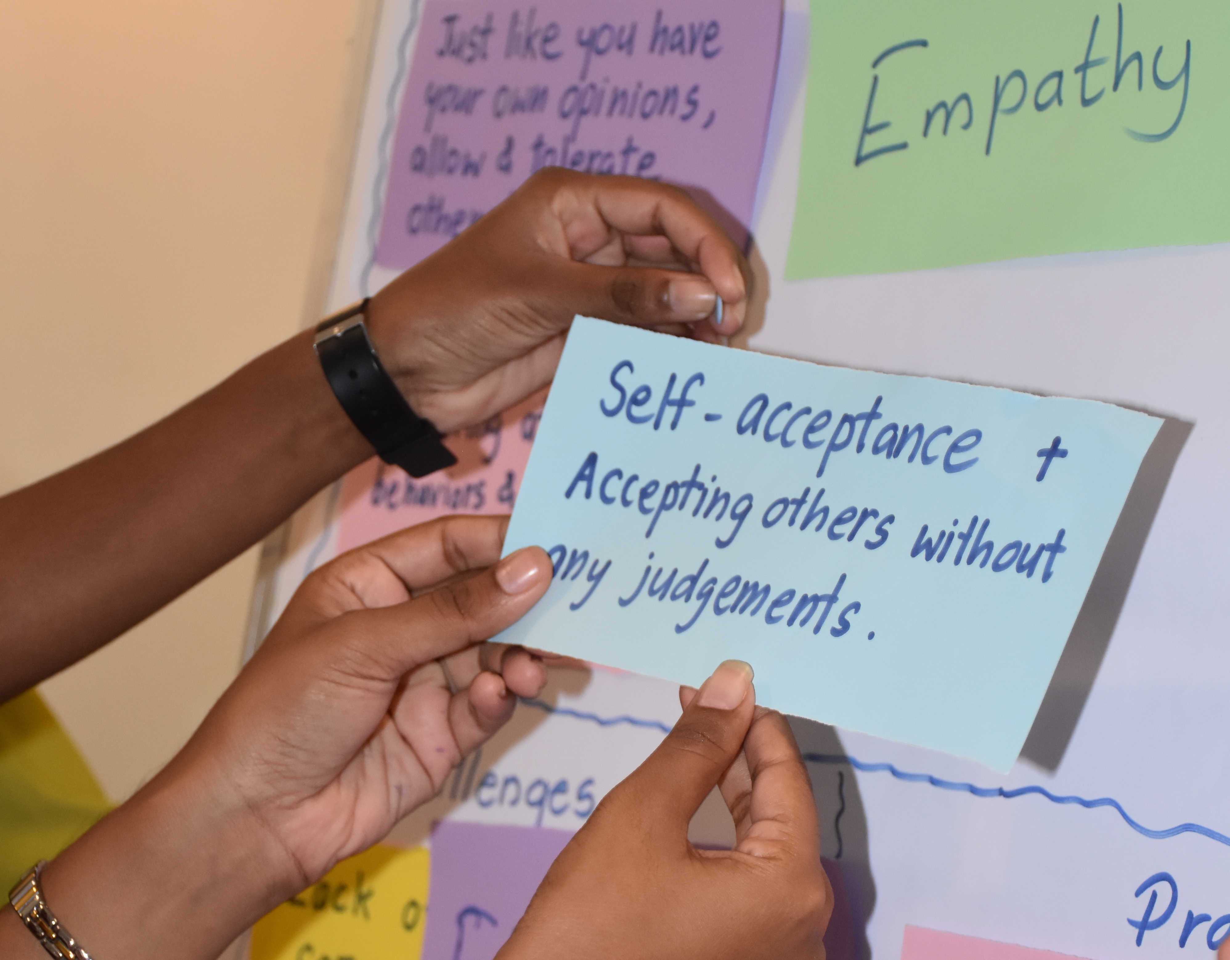 Participants hold up a post it note at a Faith in the Commonwealth programme 