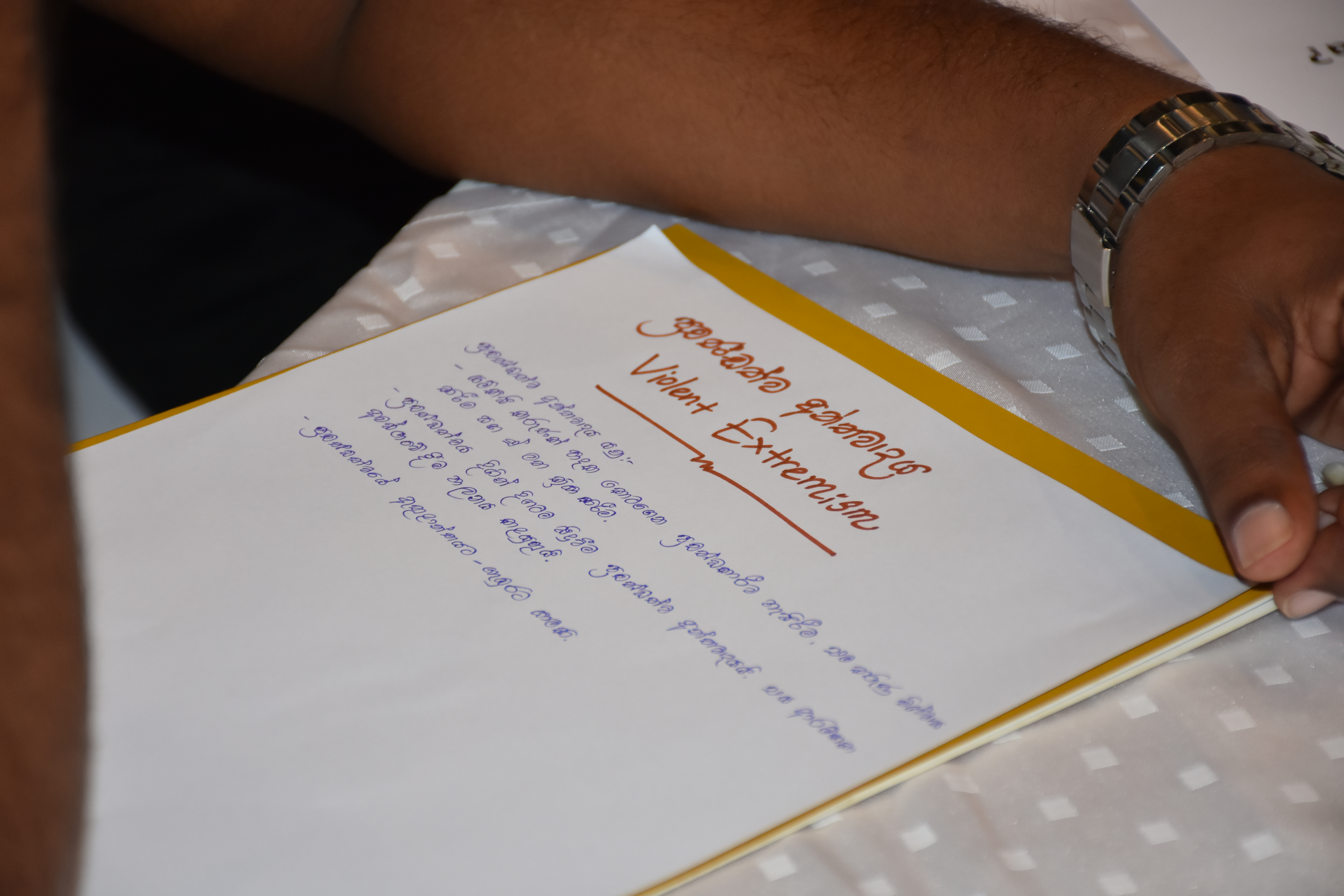 A participant takes notes at a Faith in the Commonwealth programme 