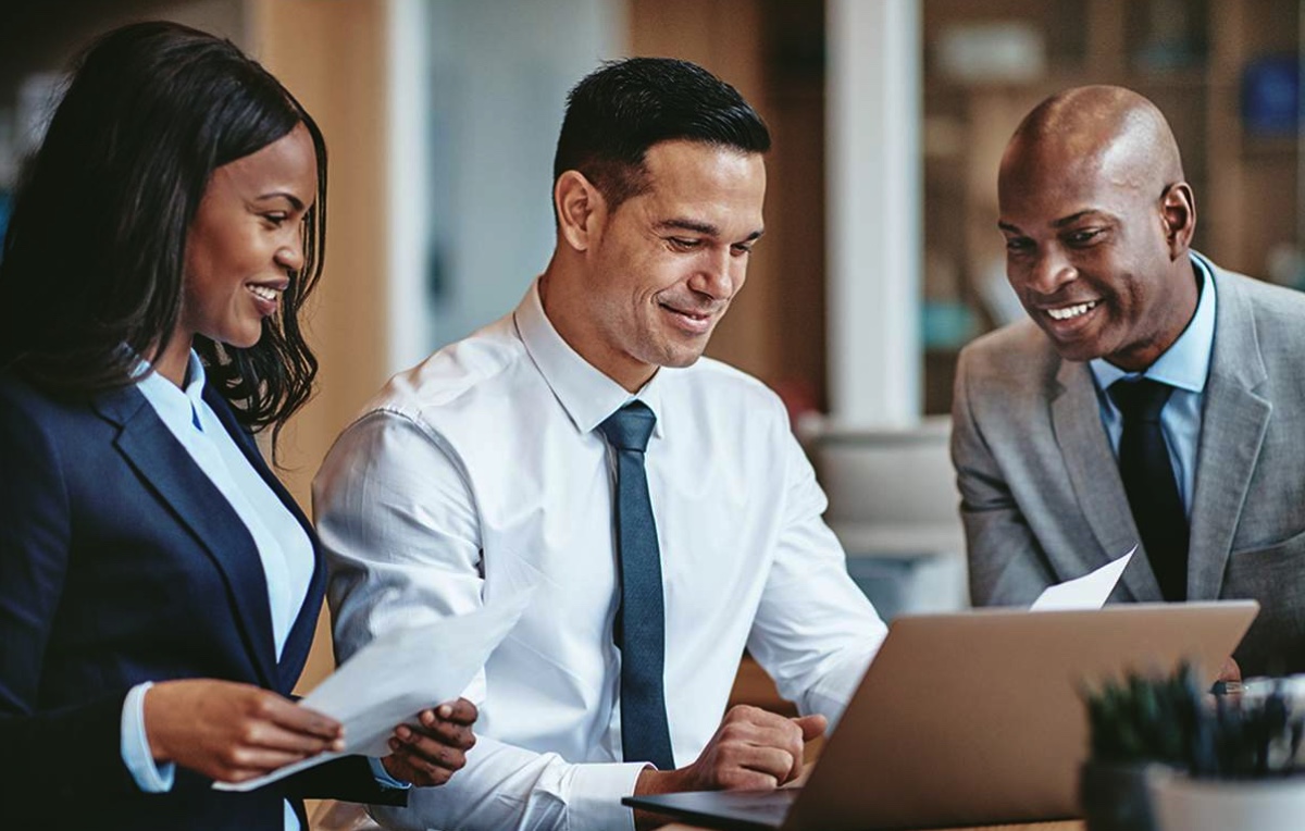 Three people at laptop