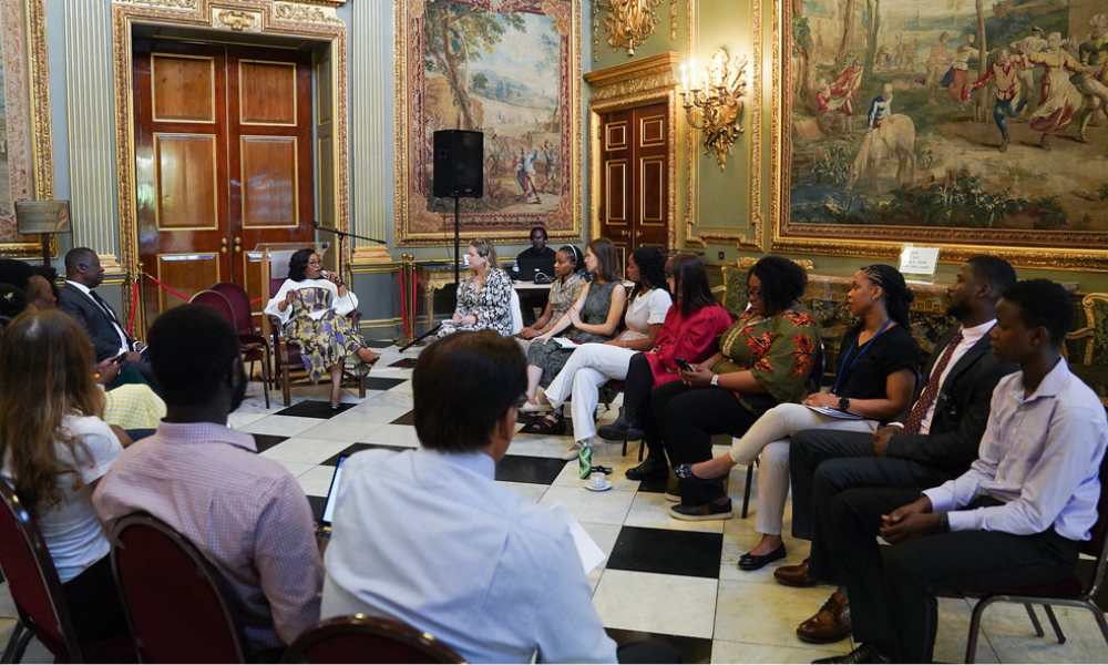 Young professionals working at the Commonwealth Secretariat sitting in a circle with the Commonwealth Secretary-General