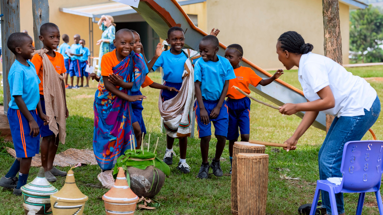 A woman plays the drums with children are dancing