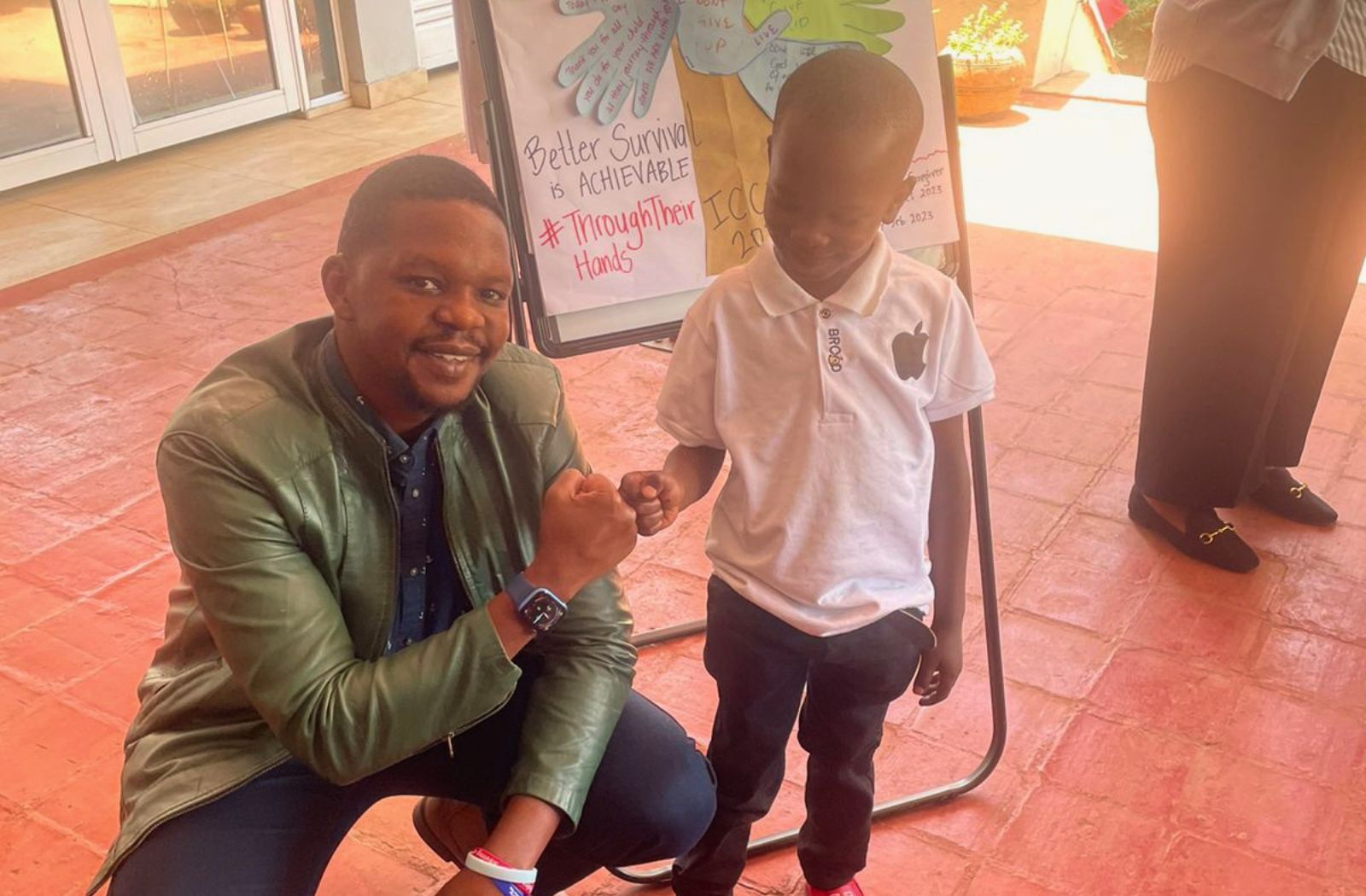Sidney Chahonyo fist bumps with a child