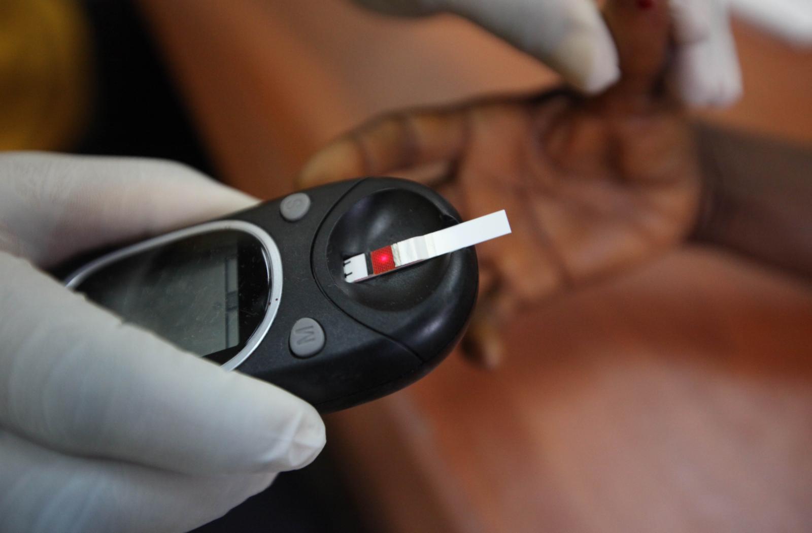 A doctor takes a blood sample from a patient at a hospital in Lagos