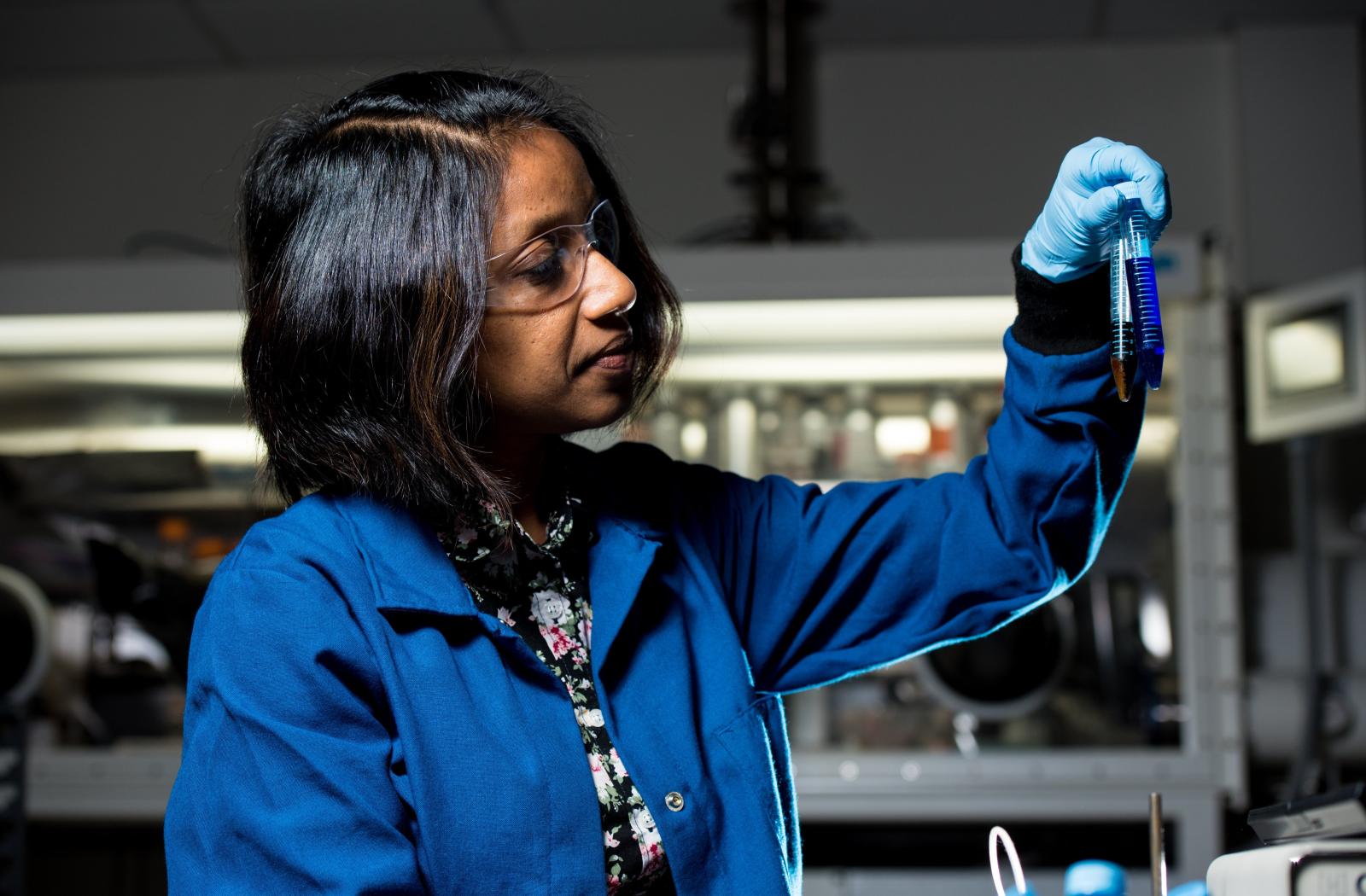 A female scientist holding two test tubes