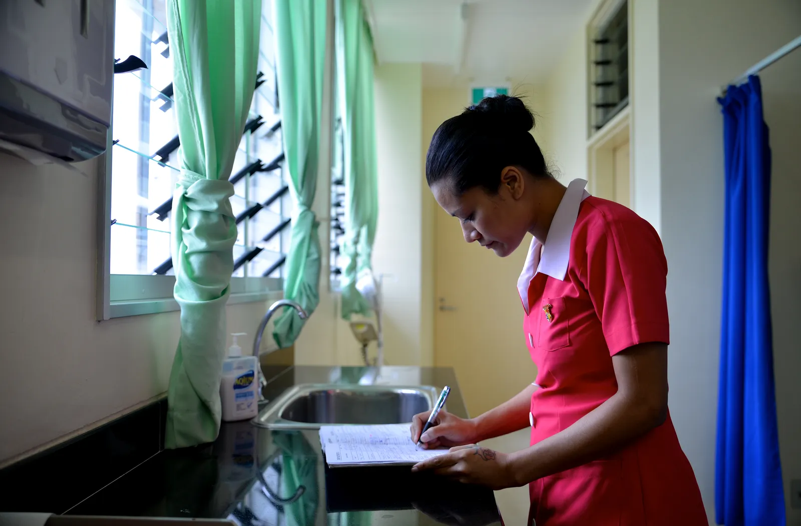 A nurse writes in a notebook at a hospital in Tonga