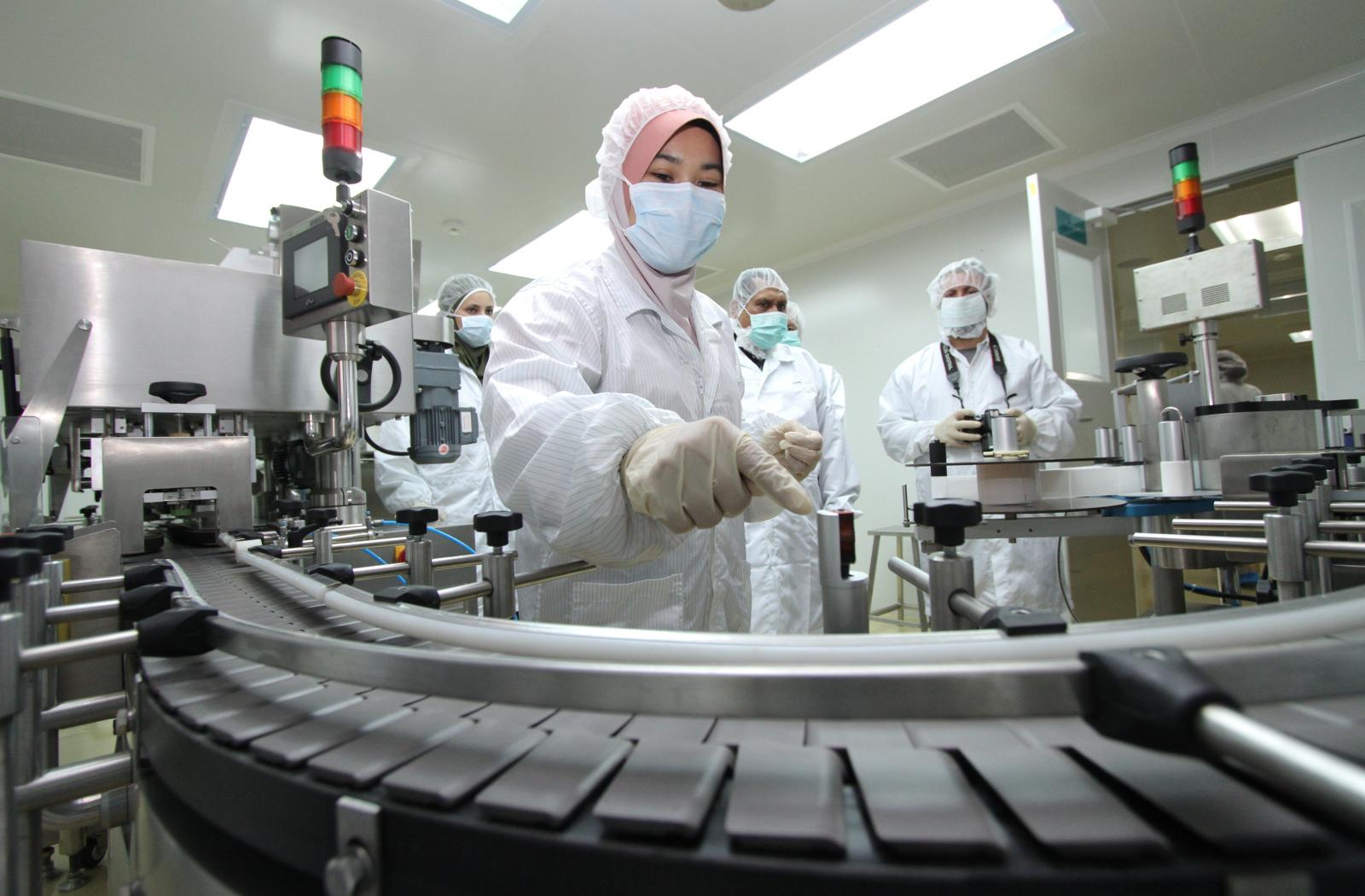 Medical professionals in masks looking at equipment
