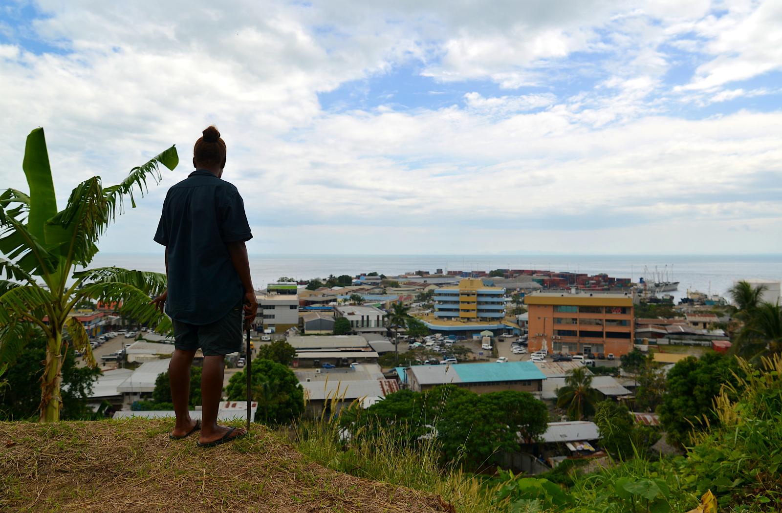 A gardener working on the grounds of Solomon Islands National Parliament takes in the view of the capital