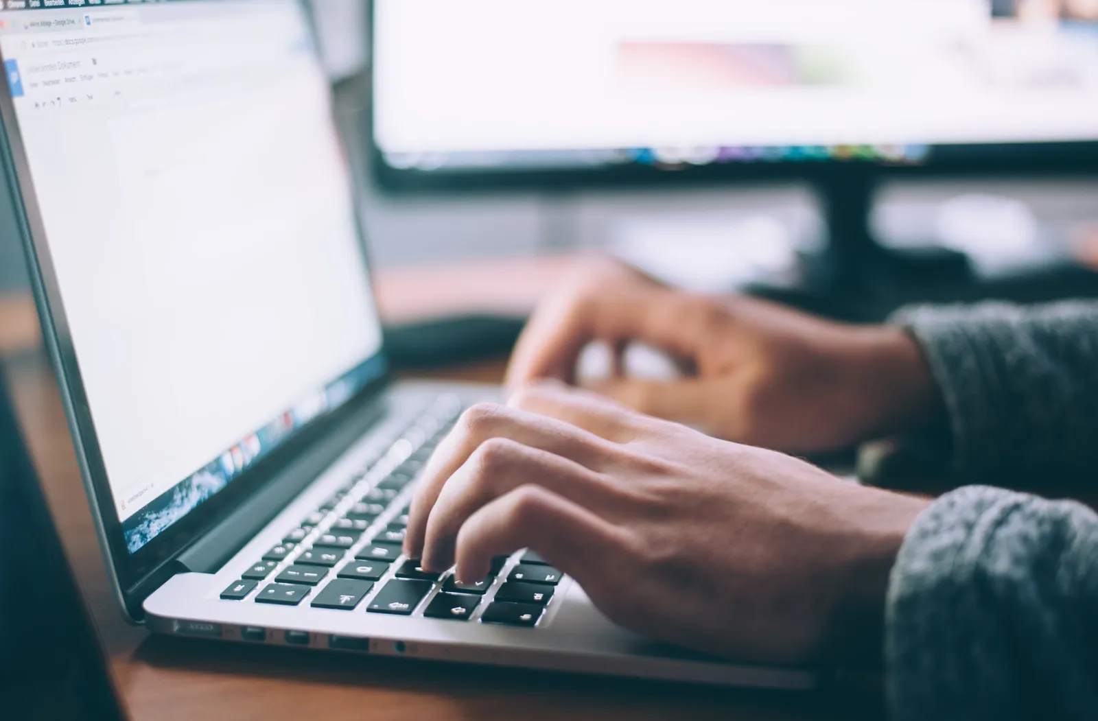 A person types on a laptop