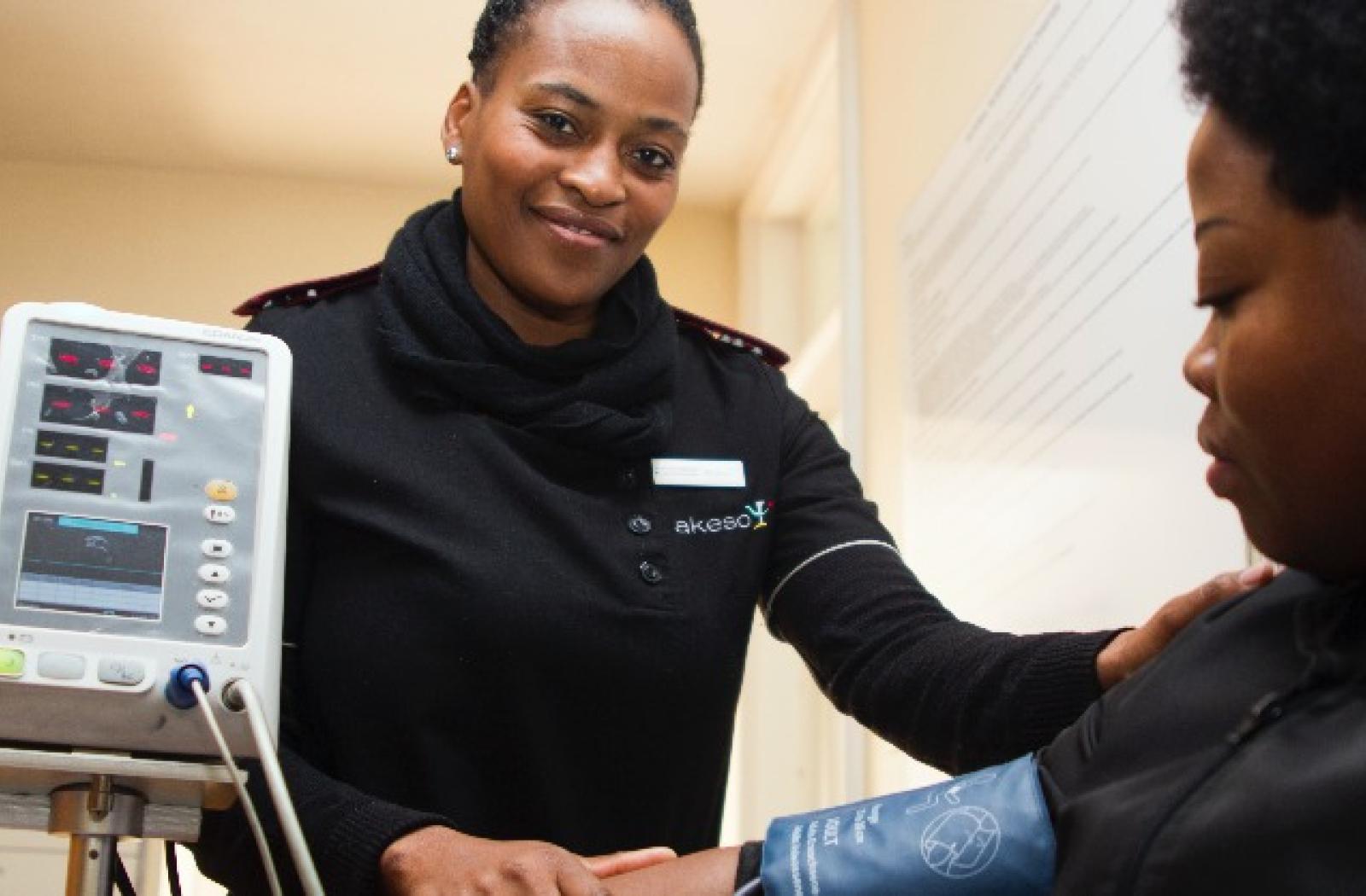 A nurse taking blood pressure of patient