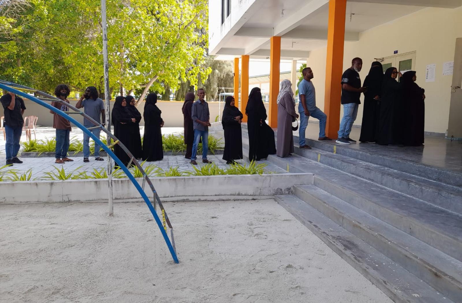 People in the Maldives wait to cast their vote at a polling station