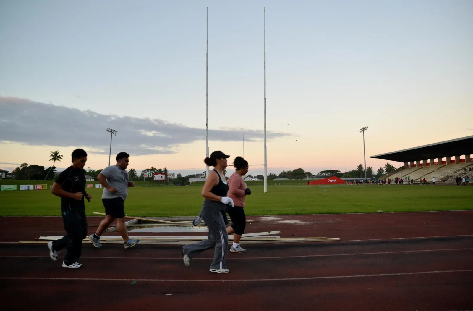 People running laps in a sports stadium