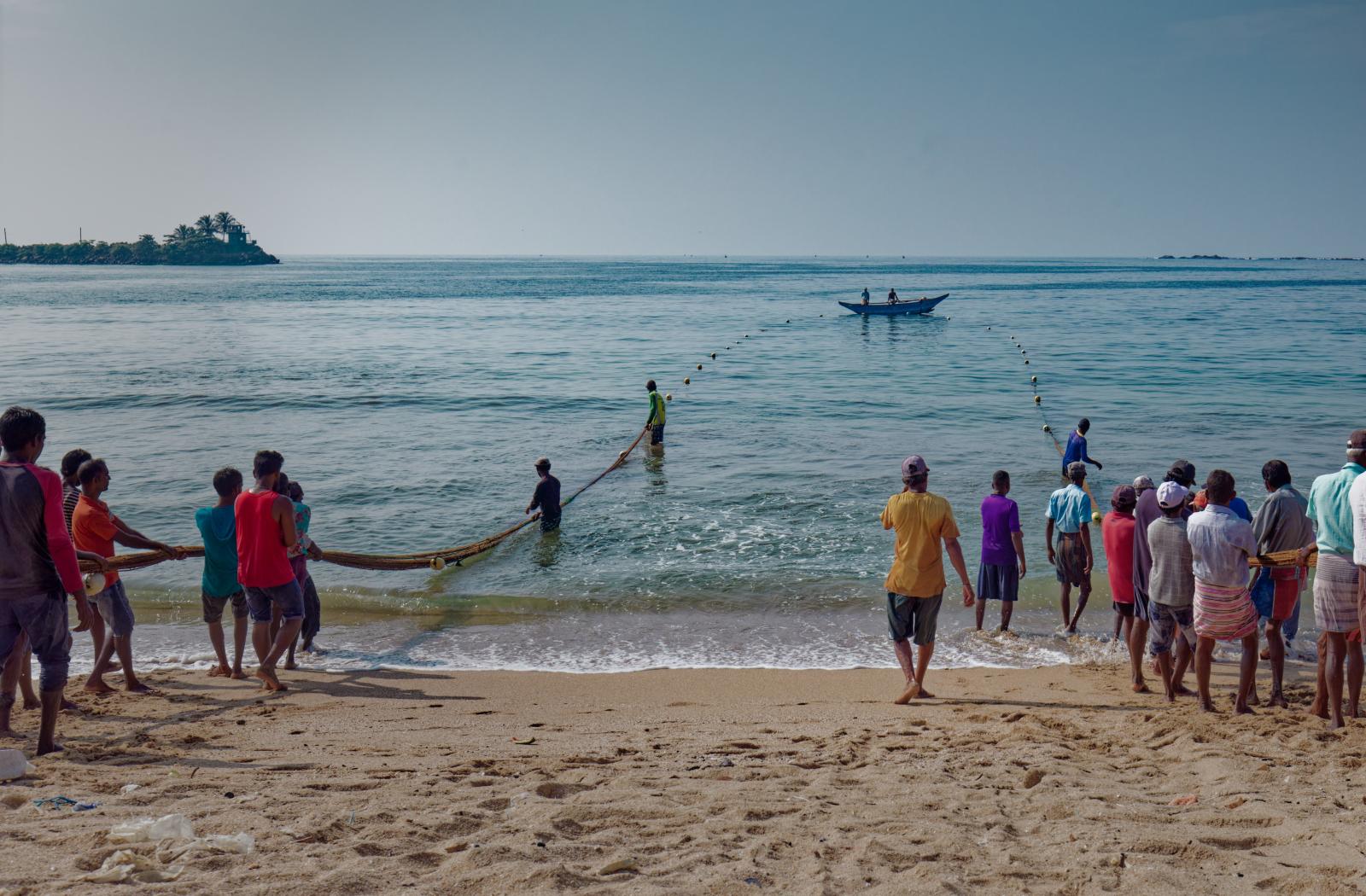 People pull in fishing nets