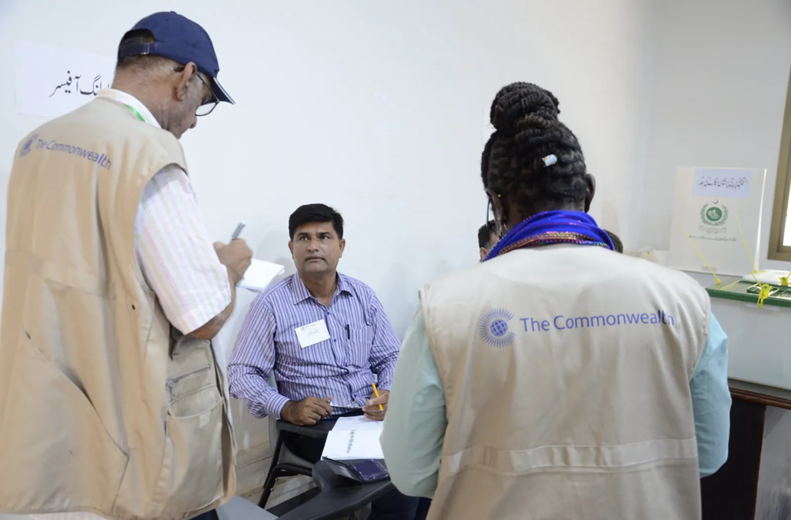 two commonwealth election observers with Pakistan officer