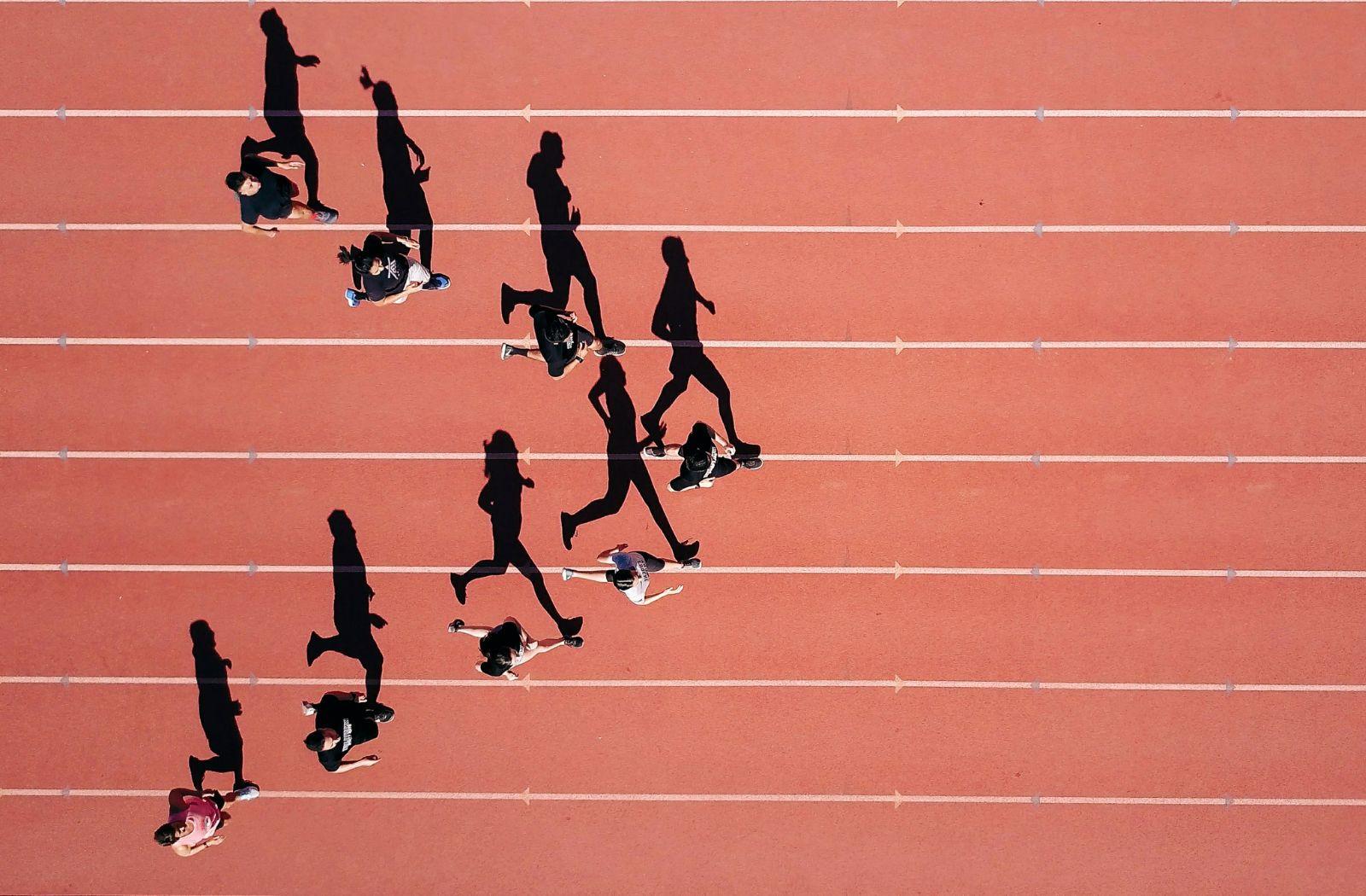 Aerial view of 8 runners on track in silhouette