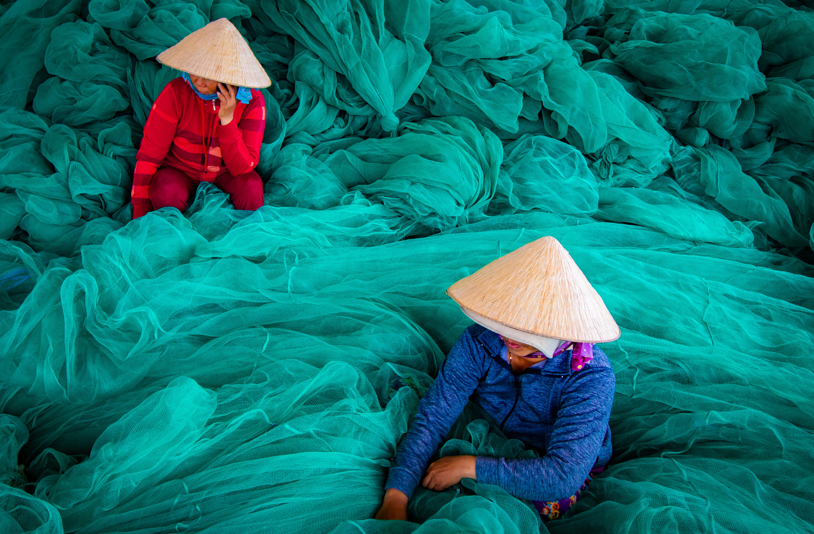 Two Women Surrounded with Green Fish Nets