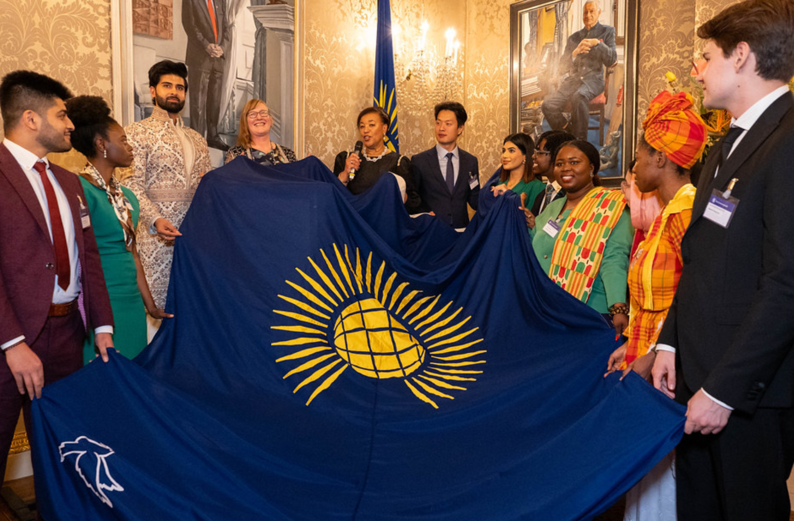 Commonwealth Secretary-General and youth leaders holding the Commonwealth flag