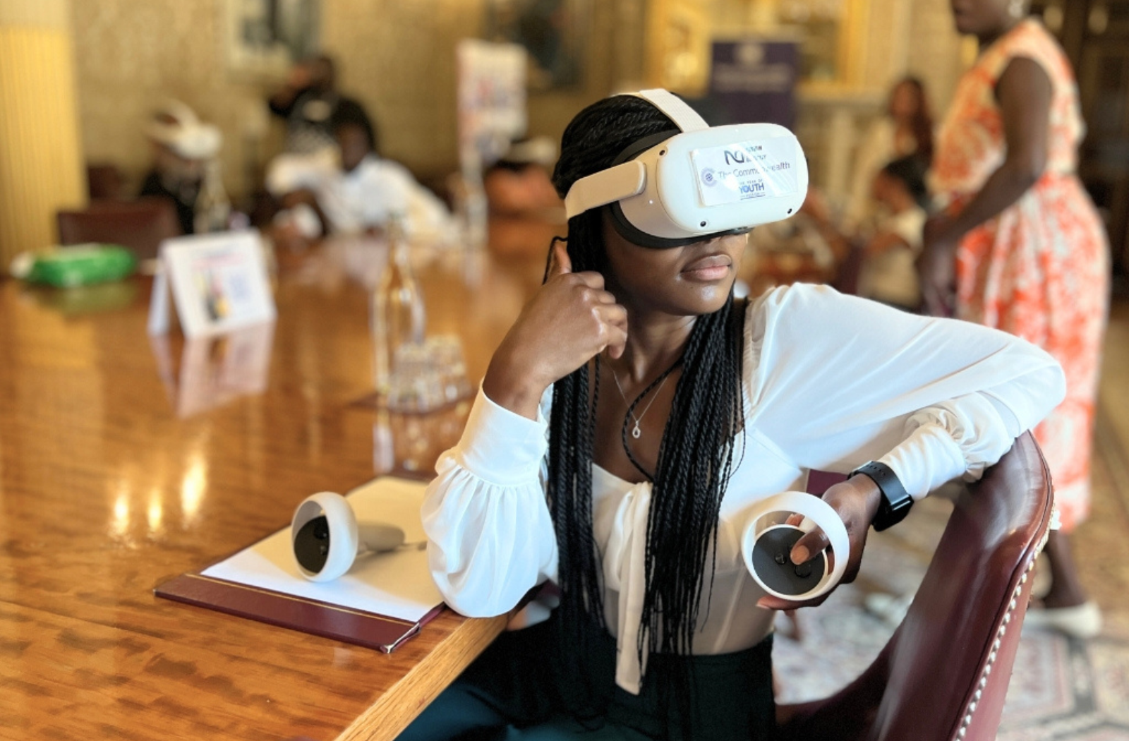 woman wears virtual reality headset to experience the Commonwealth Youth virtual museum
