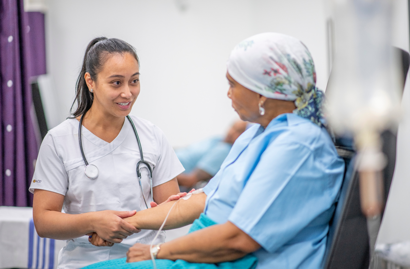 A woman receives cancer treatment from a doctor