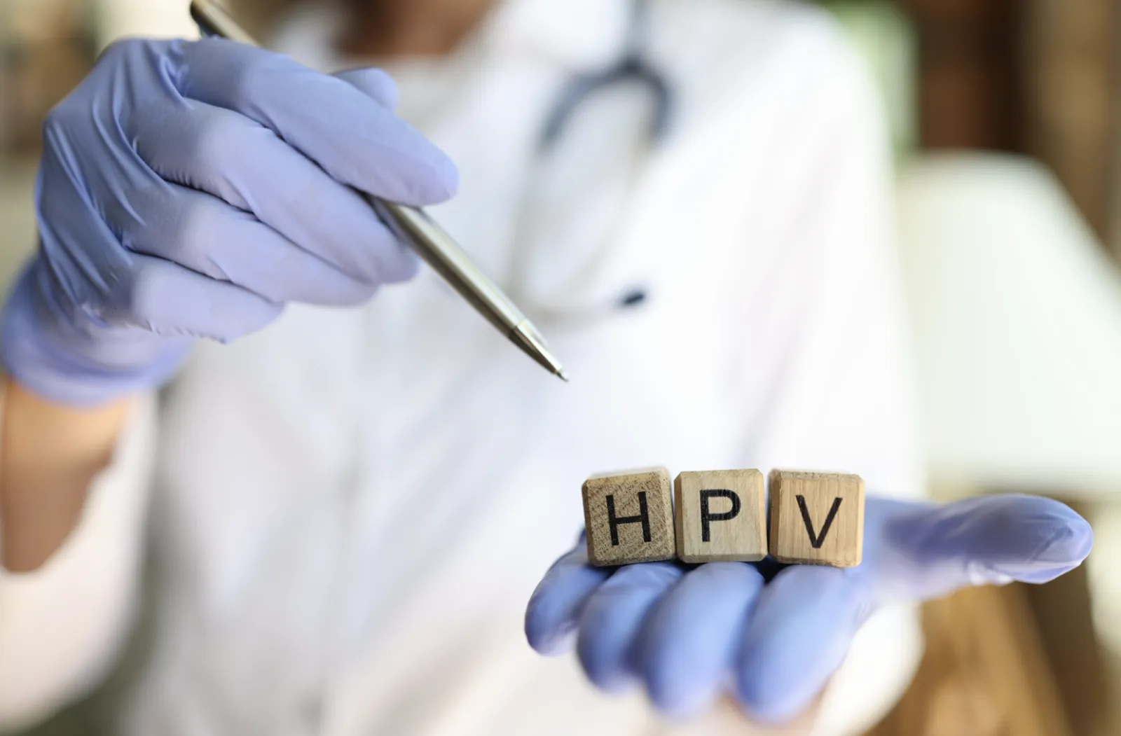 Hand with doctors gloves holding HPV wooden letters