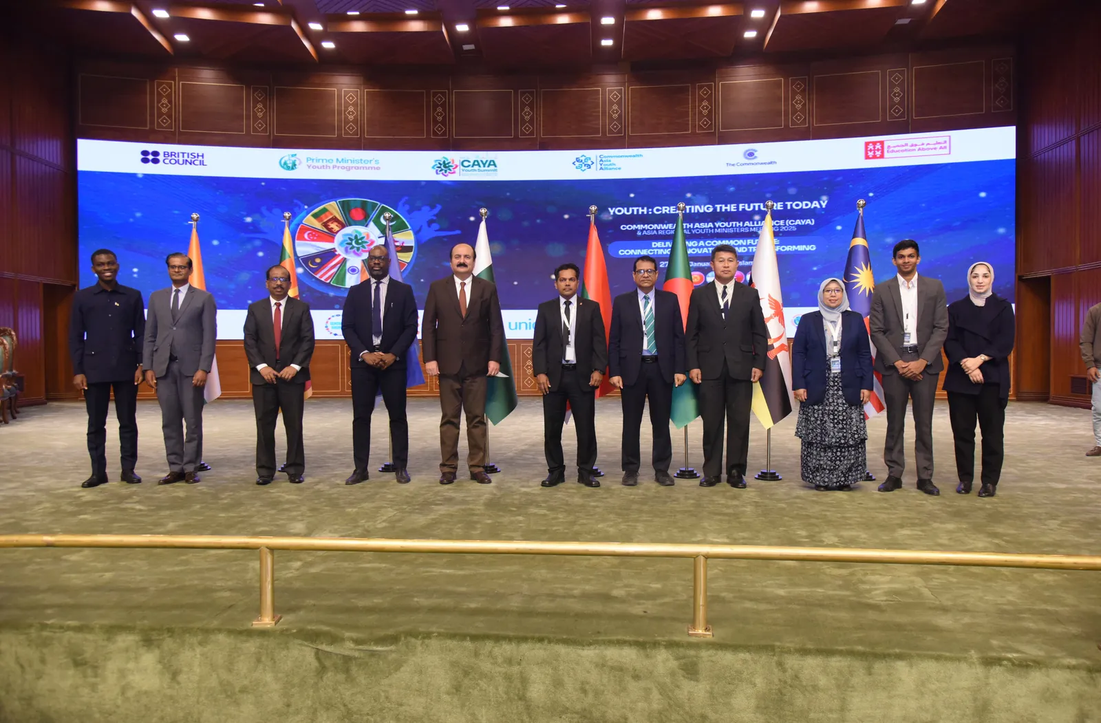 11 people standing on a stage