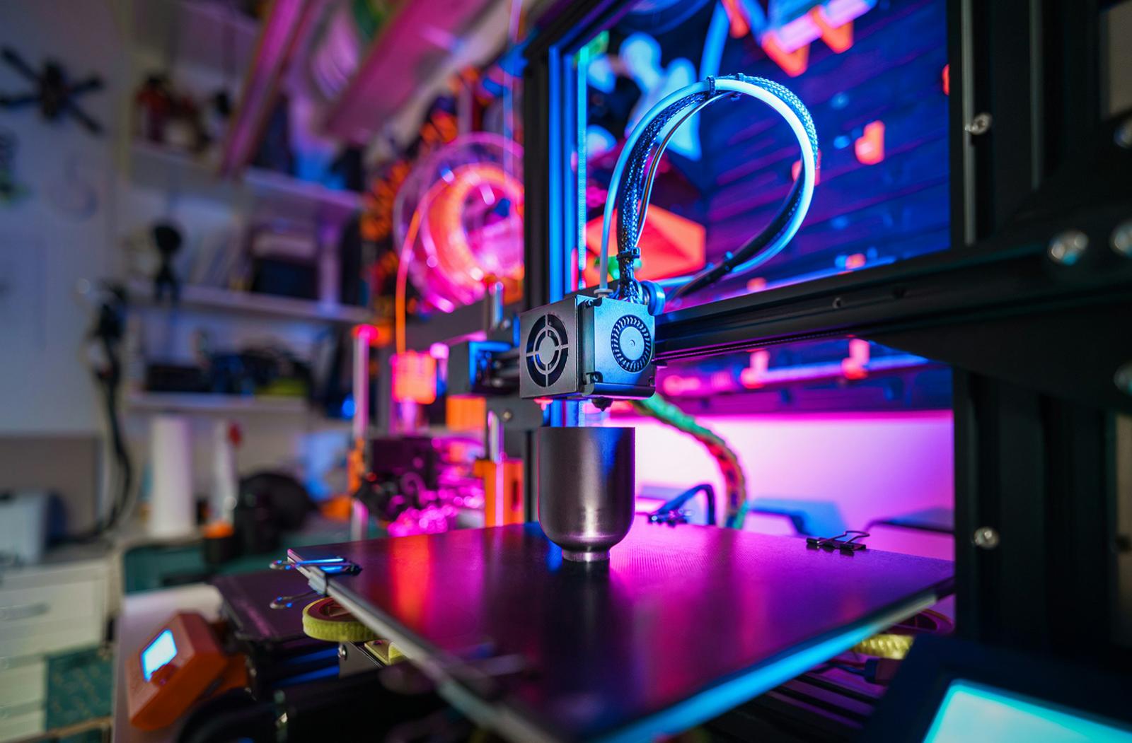 A 3D printer with a printed object on the worktop, in a home workshop. Photographer: Jakub Żerdzicki