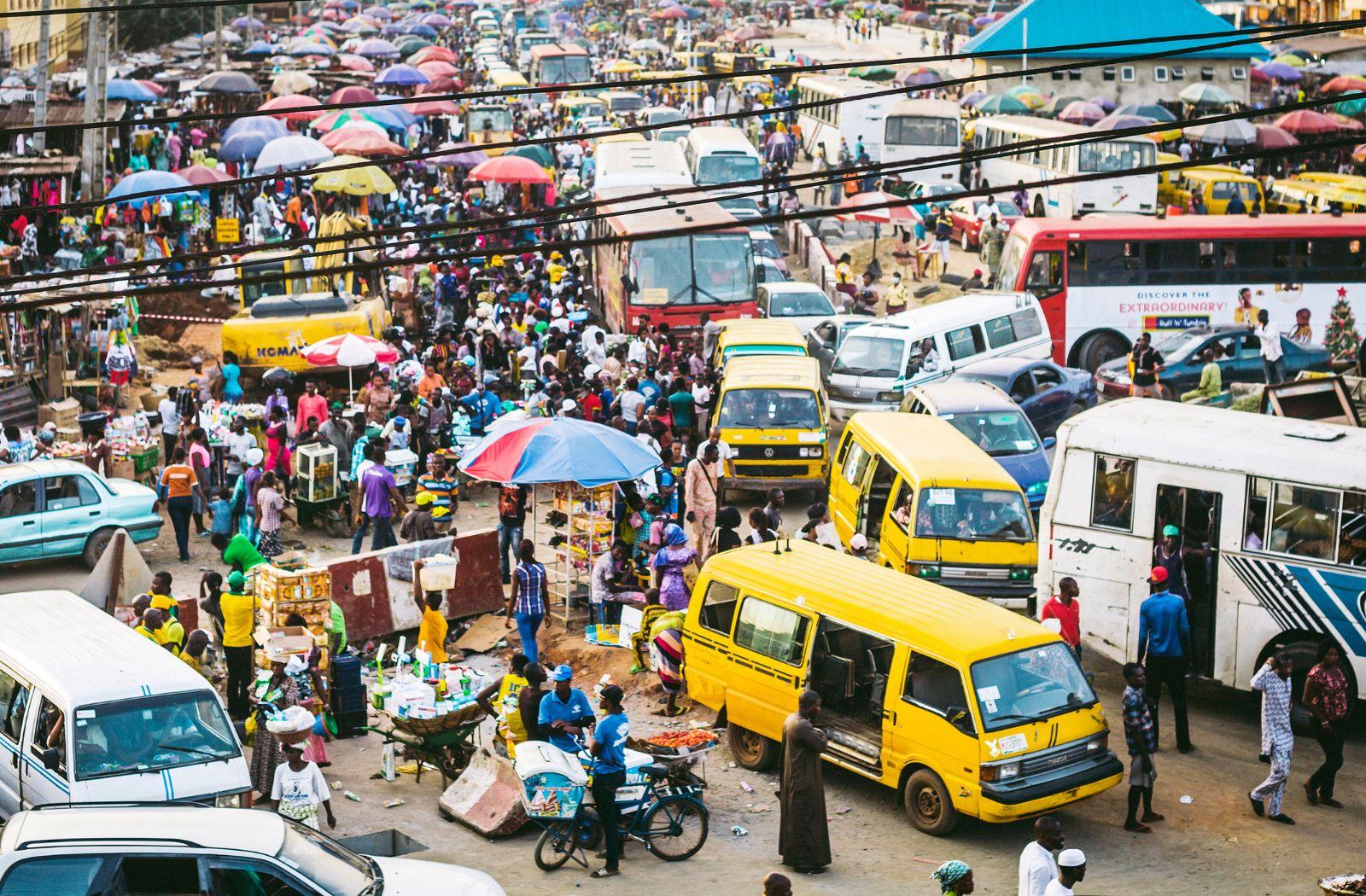 Busy market place with busses and cars