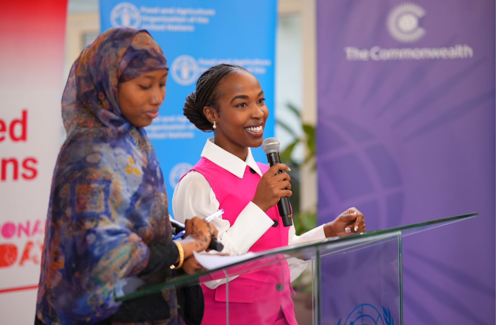 Two women stand together in front of a podium
