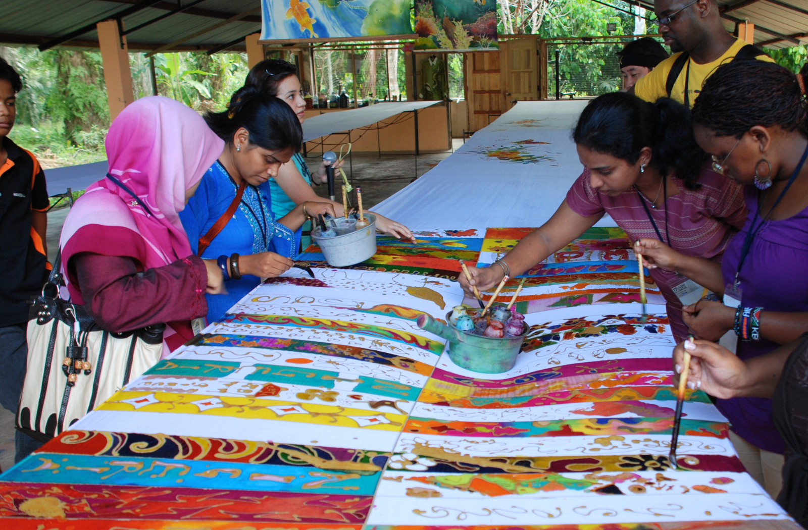 A group of young people paint colourful patterns onto fabric