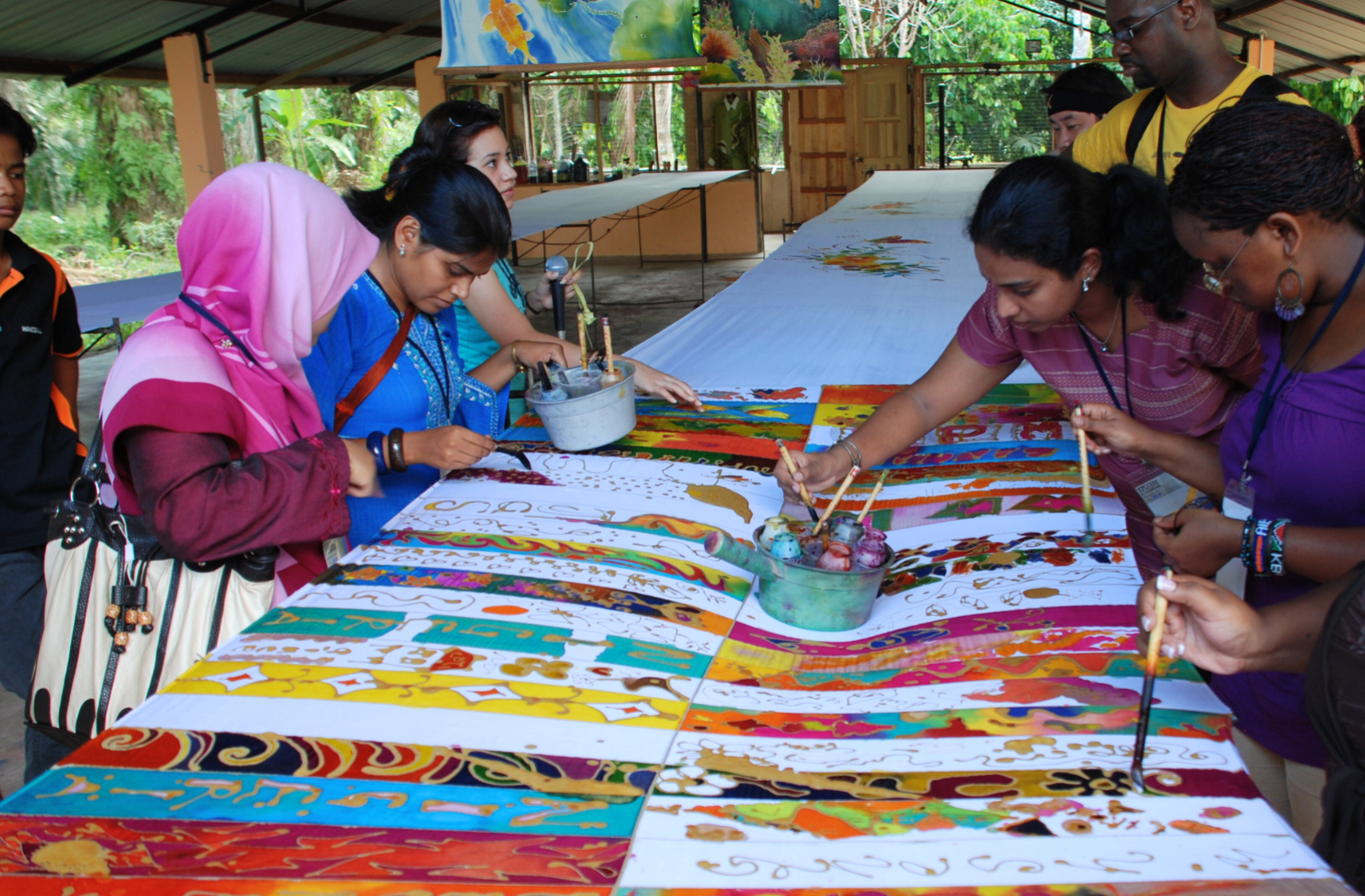 A group of young people paint colourful patterns onto fabric