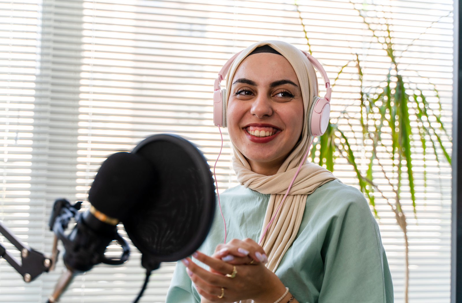 A woman in a hijab speaks into a microphone