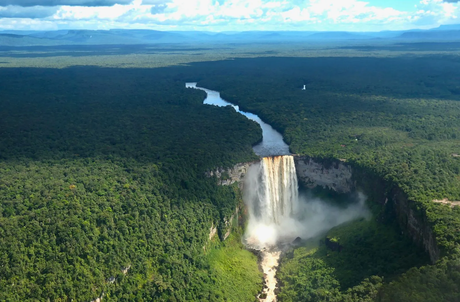 Aerial view of a waterfall surrounded by forest in Guyana