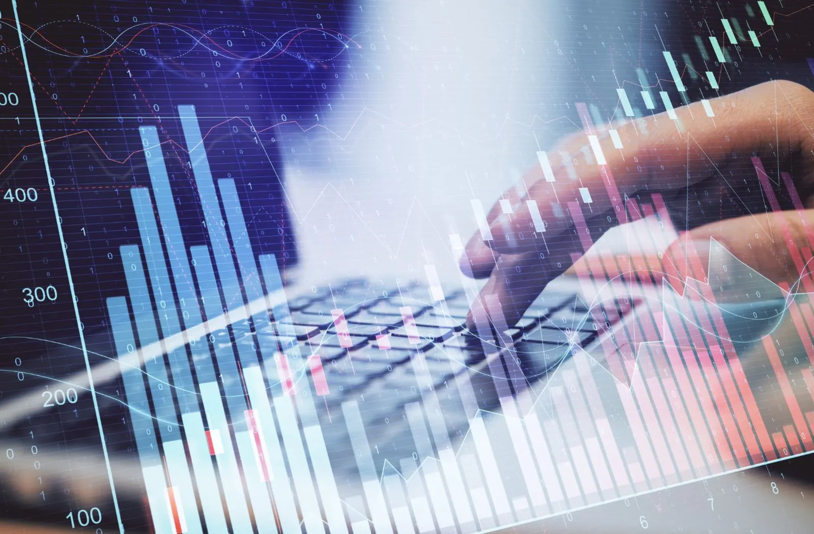 Financial market chart with someone typing on a laptop