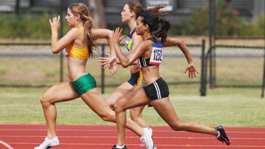 Three female athletes on a race track