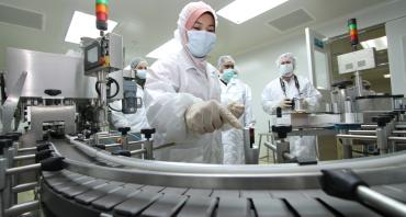 Medical professionals in masks looking at equipment