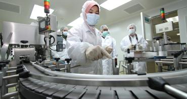 Medical professionals in masks looking at equipment