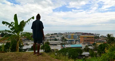 A gardener working on the grounds of Solomon Islands National Parliament takes in the view of the capital