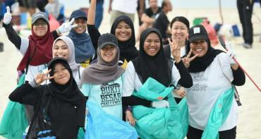 Youth in Malaysia picking up litter on a beach