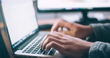 A person types on a laptop