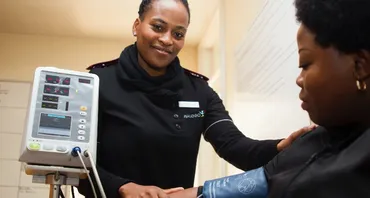 A nurse taking blood pressure of patient