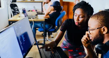 Two people look at a computer screen