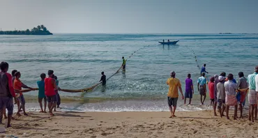People pull in fishing nets