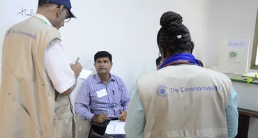 two commonwealth election observers with Pakistan officer