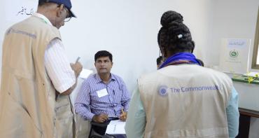 two commonwealth election observers with Pakistan officer