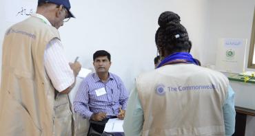 two commonwealth election observers with Pakistan officer