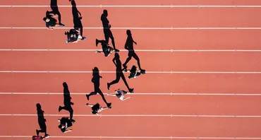 Aerial view of 8 runners on track in silhouette