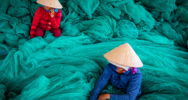 Two Women Surrounded with Green Fish Nets