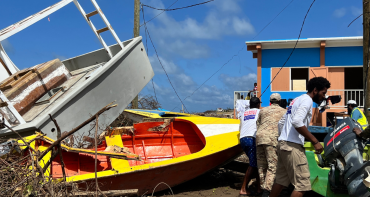 People unblocking a road in Carriacou after Hurricane Beryl