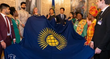 Commonwealth Secretary-General and youth leaders holding the Commonwealth flag